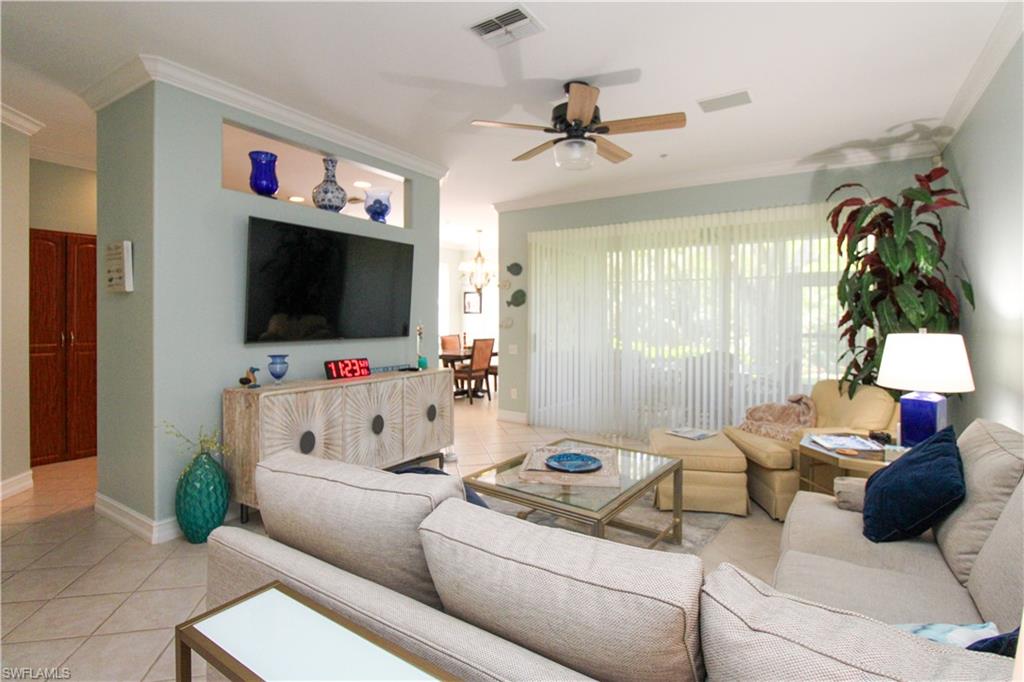 817 Carrick Bend Circle, Unit 101 Naples, FL 34110 - Photo 23 of 49 a living room with furniture and a flat screen tv