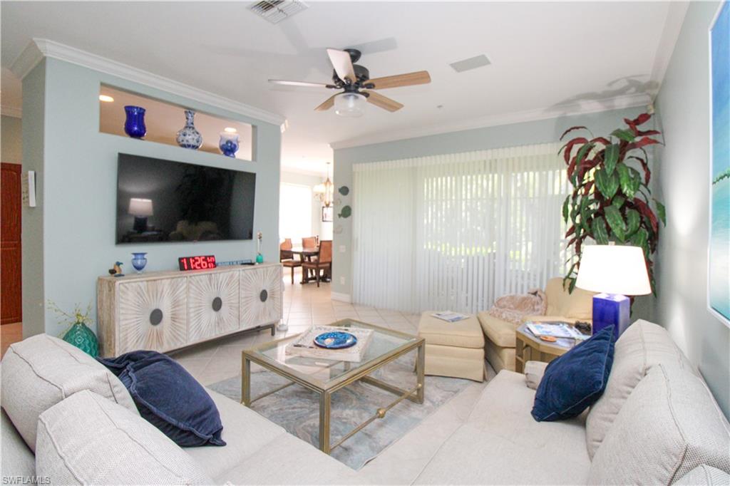 817 Carrick Bend Circle, Unit 101 Naples, FL 34110 - Photo 24 of 49 a living room with furniture and a flat screen tv
