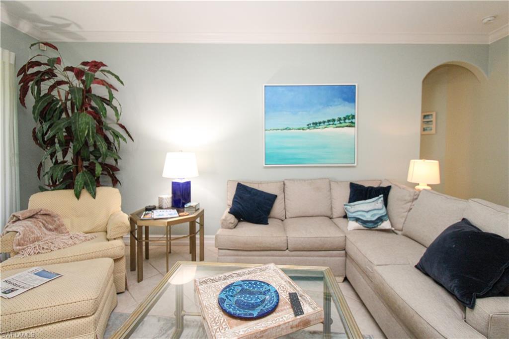 817 Carrick Bend Circle, Unit 101 Naples, FL 34110 - Photo 26 of 49 a living room with furniture and a lamp