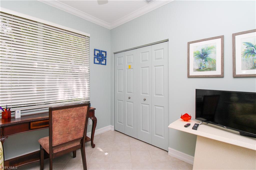 817 Carrick Bend Circle, Unit 101 Naples, FL 34110 - Photo 27 of 49 a room with furniture and a fireplace