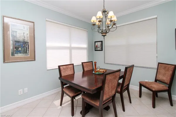 a view of a dining room with furniture a chandelier and wooden floor