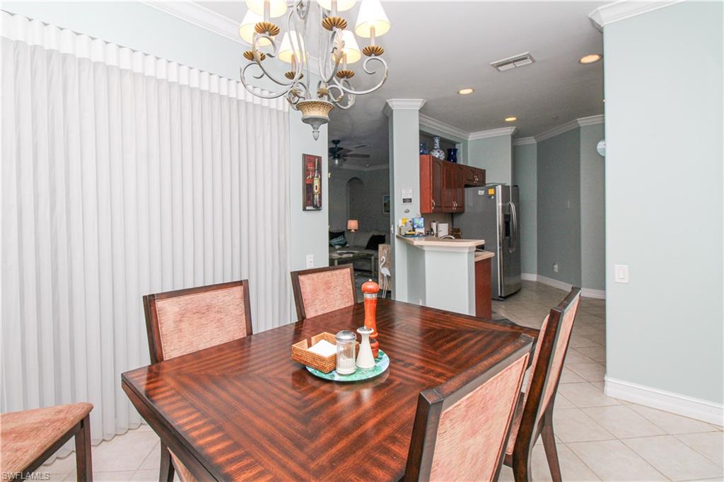 817 Carrick Bend Circle, Unit 101 Naples, FL 34110 - Photo 29 of 49 a dining room with furniture and a chandelier