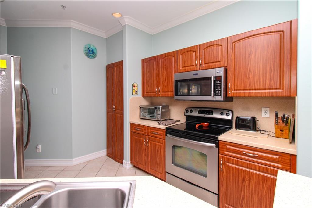 817 Carrick Bend Circle, Unit 101 Naples, FL 34110 - Photo 30 of 49 a kitchen with stainless steel appliances granite countertop a refrigerator stove and microwave