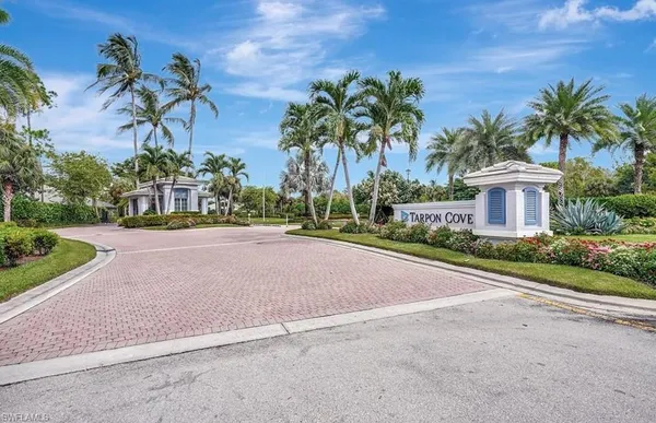 a view of a house with palm trees and a small yard