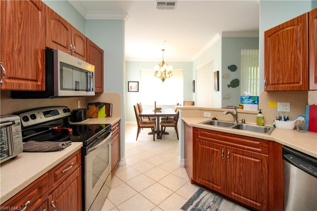 817 Carrick Bend Circle, Unit 101 Naples, FL 34110 - Photo 33 of 49 a kitchen with a sink stove and cabinets