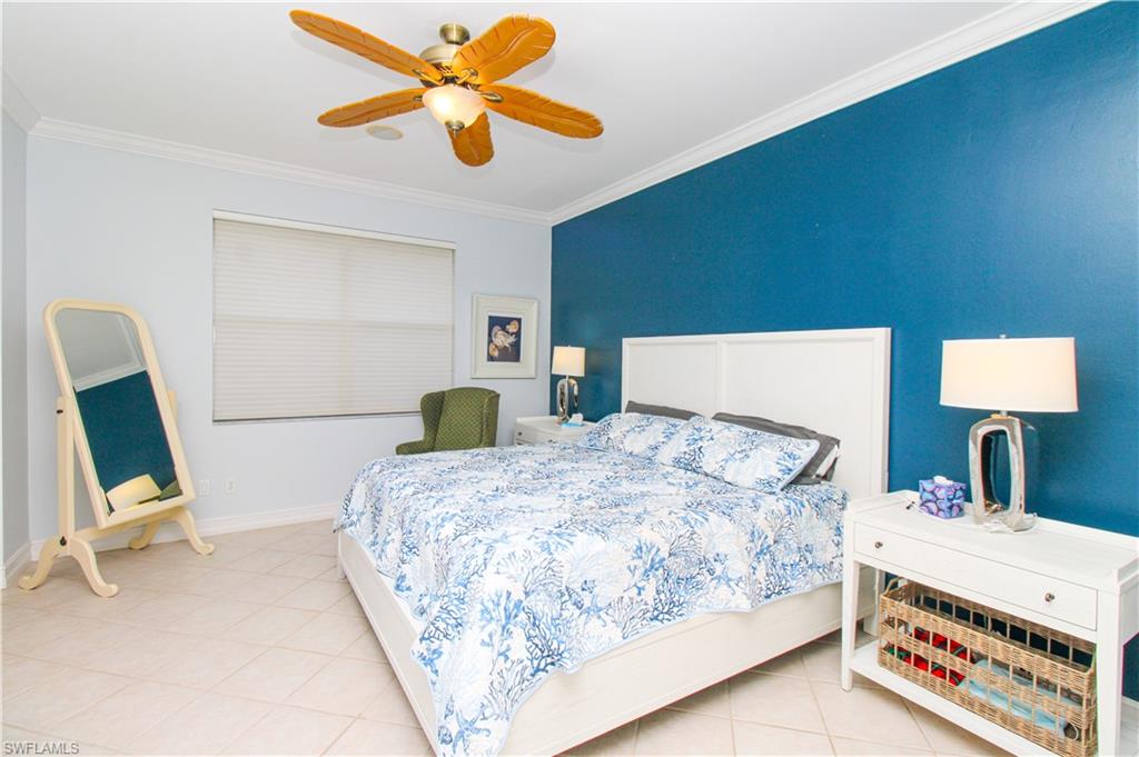 817 Carrick Bend Circle, Unit 101 Naples, FL 34110 - Photo 35 of 49 a bedroom with a bed a desk and chair