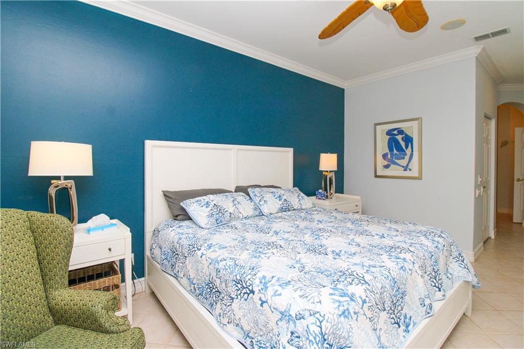 817 Carrick Bend Circle, Unit 101 Naples, FL 34110 - Photo 37 of 49 a bedroom with a bed and wooden floor