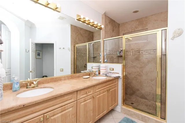 a bathroom with a granite countertop sink mirror and shower
