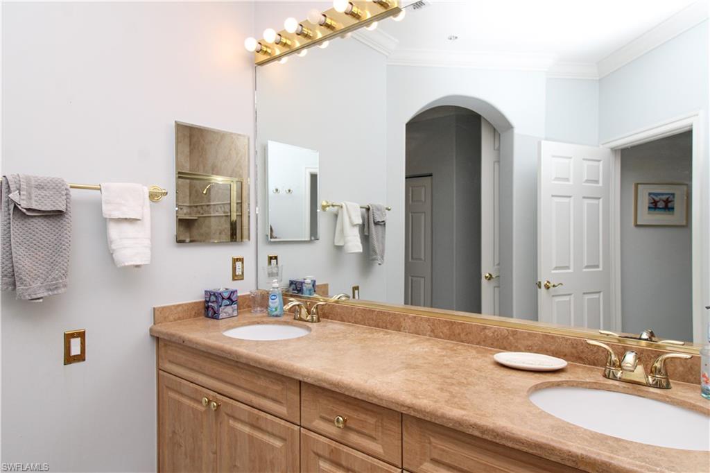 817 Carrick Bend Circle, Unit 101 Naples, FL 34110 - Photo 40 of 49 a bathroom with a granite countertop sink and a mirror