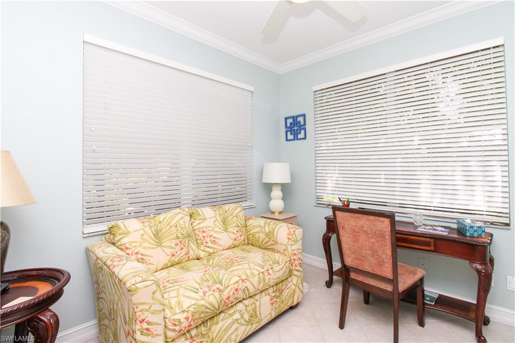 817 Carrick Bend Circle, Unit 101 Naples, FL 34110 - Photo 43 of 49 a bedroom with a bed and a chair