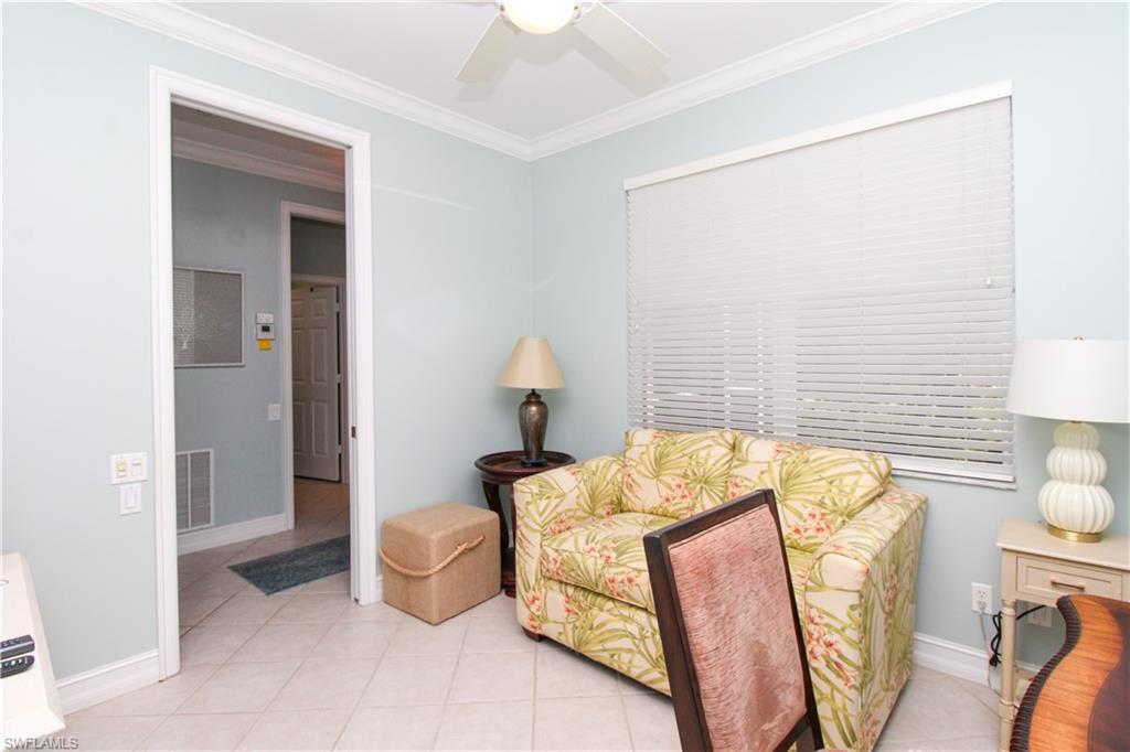 817 Carrick Bend Circle, Unit 101 Naples, FL 34110 - Photo 44 of 49 a bedroom with a bed and a table