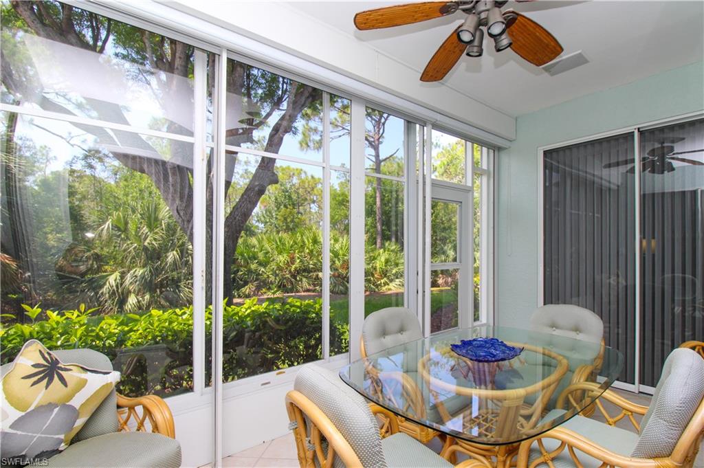 817 Carrick Bend Circle, Unit 101 Naples, FL 34110 - Photo 45 of 49 a living room with patio furniture and a floor to ceiling window