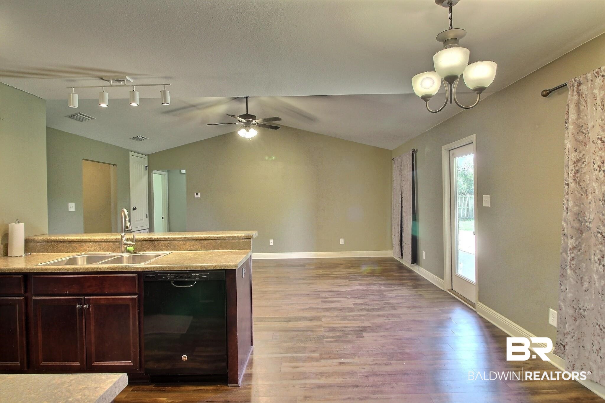 15577 Talus Court Foley, AL 36535 - Photo 26 of 28 Kitchen featuring light countertops, black dishwasher, vaulted ceiling, dark wood-style floors, and open floor plan