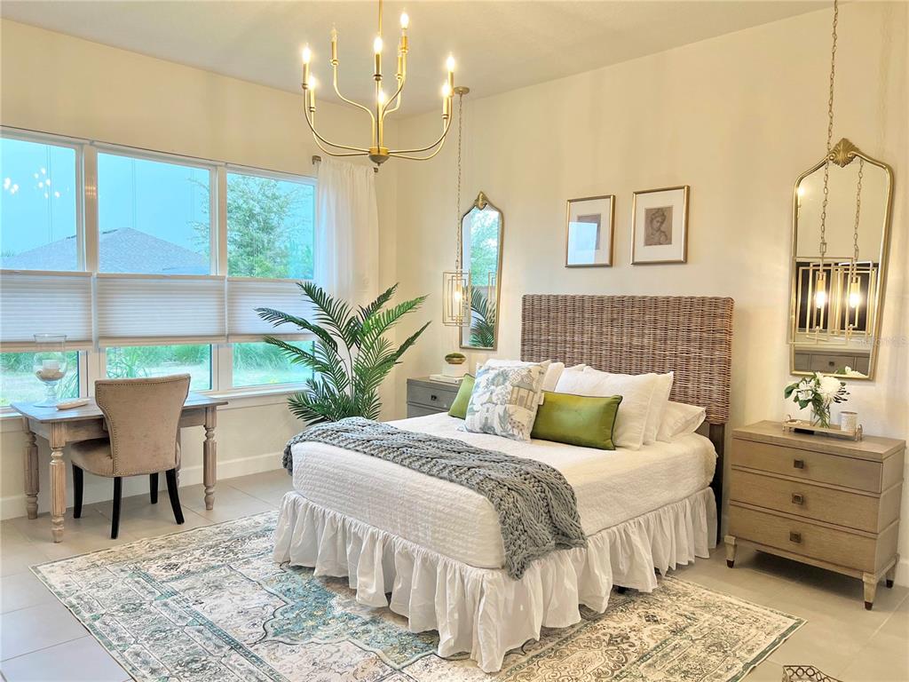 2337 Clemblue Road Clermont, FL 34715 - Photo 16 of 33 a bedroom with a large bed and a chandelier