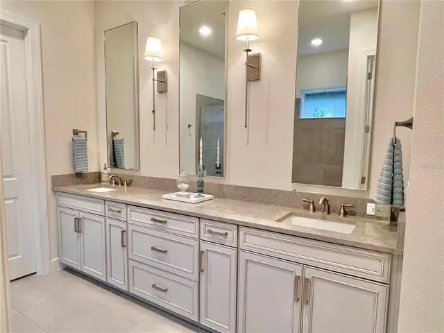 a bathroom with double vanity sinks and a mirror