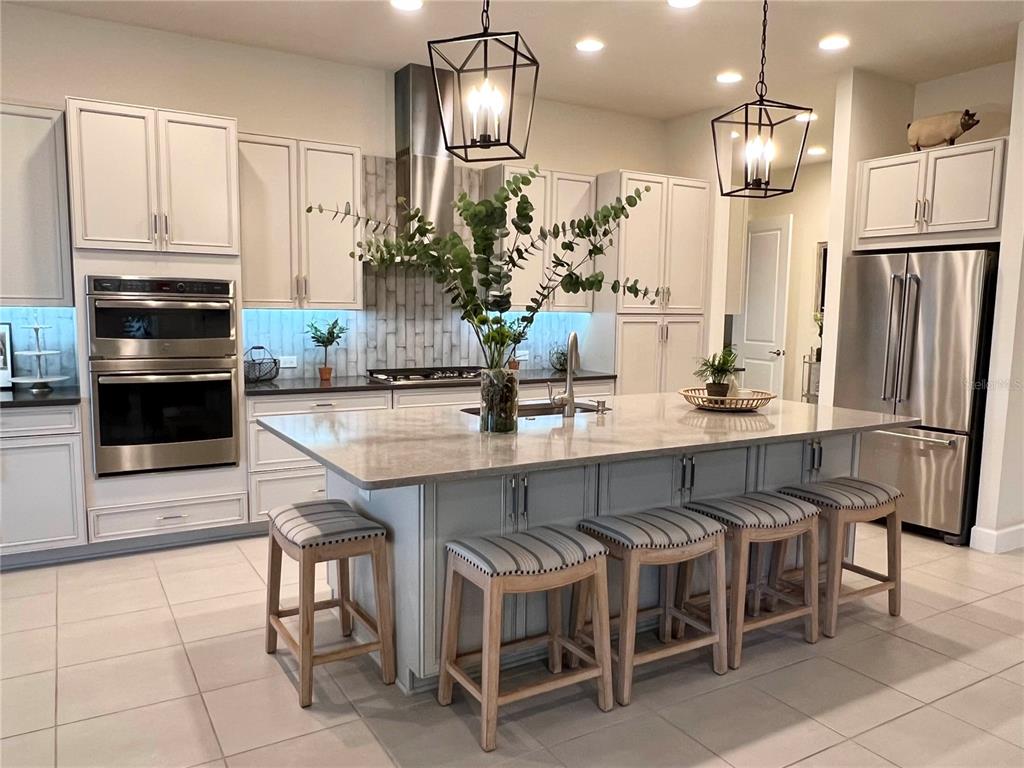 2337 Clemblue Road Clermont, FL 34715 - Photo 8 of 33 a kitchen with stainless steel appliances a dining table chairs and refrigerator