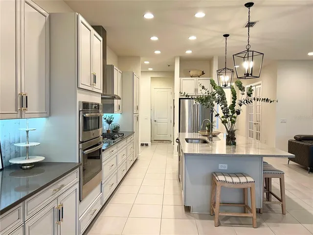 a kitchen with stainless steel appliances kitchen island granite countertop a refrigerator and a view of living room