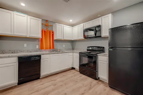 a kitchen with a refrigerator and a stove top oven