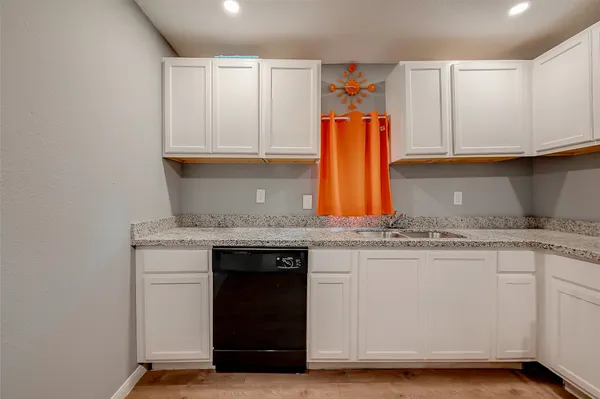 a kitchen with granite countertop a sink and cabinets