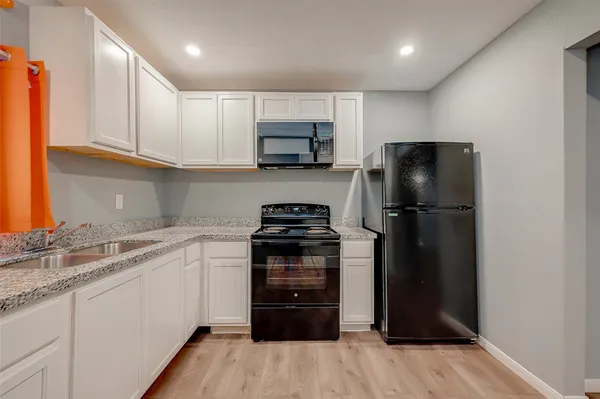 a kitchen with a refrigerator and a stove top oven