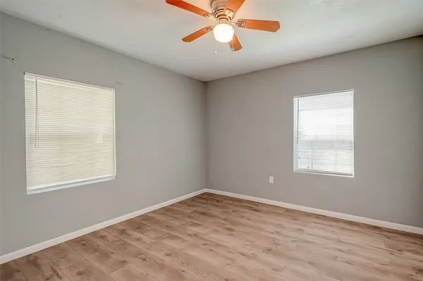 an empty room with a window and a fan