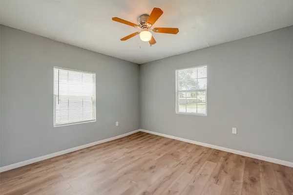 an empty room with window and a ceiling fan
