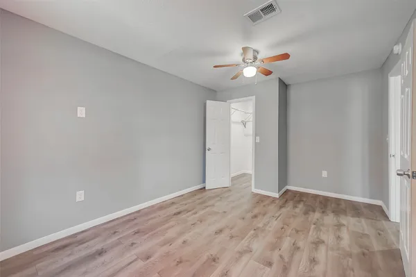 an empty room with closet and a ceiling fan