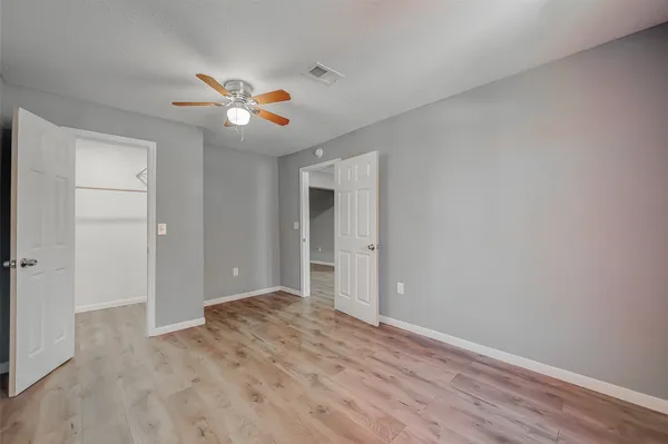 a view of empty room with wooden floor