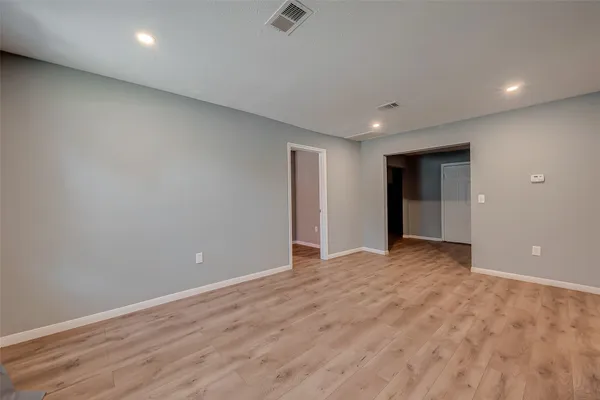 a view of an empty room with wooden floor