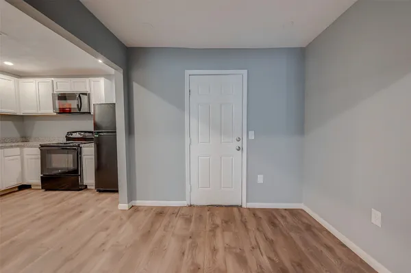 a view of kitchen with wooden floor and electronic appliances
