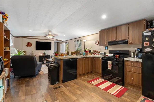 a kitchen with stainless steel appliances kitchen island granite countertop a refrigerator and a stove top oven