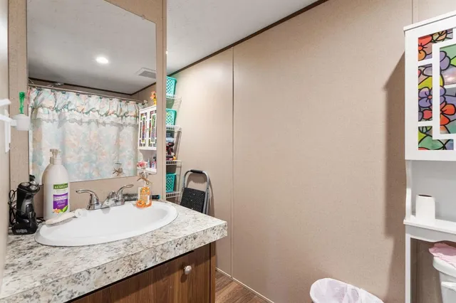 a bathroom with a granite countertop sink a toilet and shower