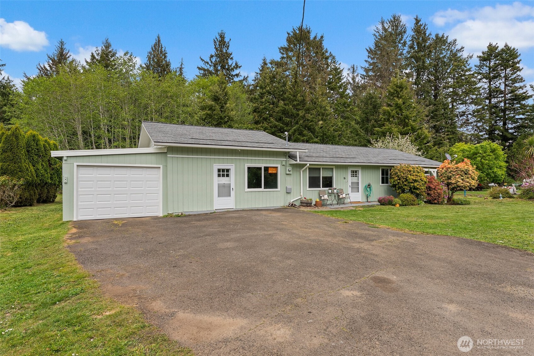 a front view of house with yard and trees in the background