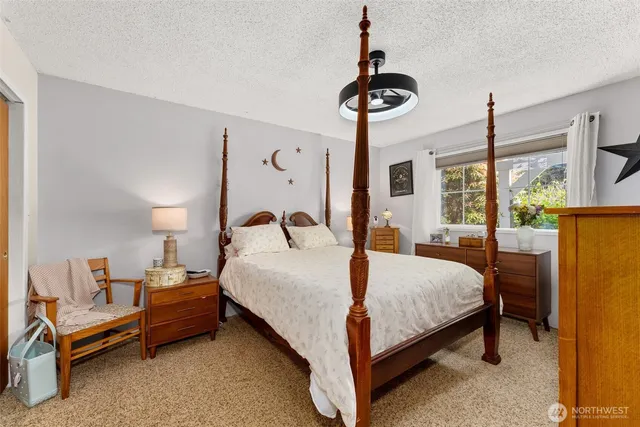 a bedroom with a bed chandelier and a window
