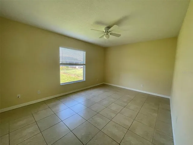 an empty room with windows and fan