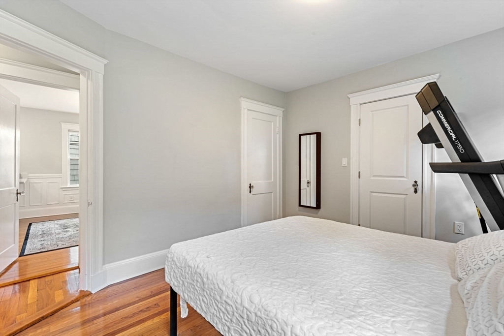 1045 Adams Street, Unit 1 Boston, MA 02124 - Photo 17 of 30 a bedroom with a bed and wooden floor