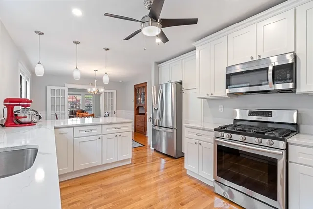 a kitchen with stainless steel appliances a stove a sink cabinets and a refrigerator