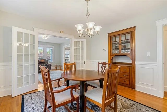 a dining room with furniture a chandelier and wooden floor