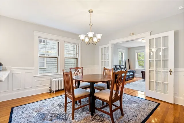 a dining room with furniture a chandelier and wooden floor