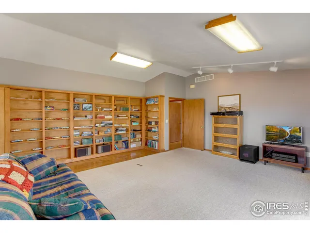 a living room with furniture a flat tv screen and gym equipment