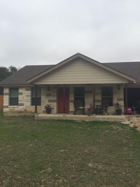 a front view of a house with a garden and chairs