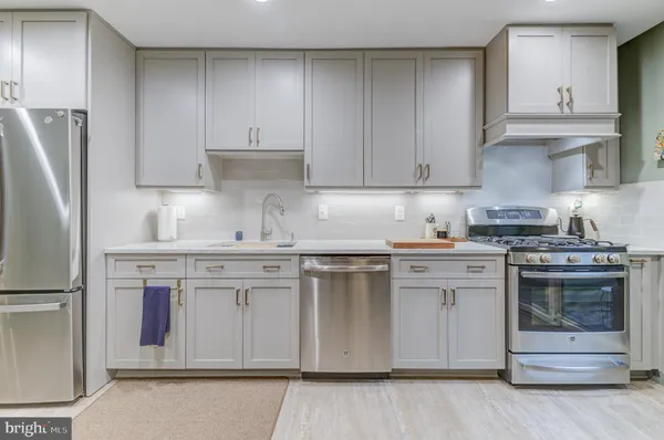 a kitchen with granite countertop white cabinets and stainless steel appliances
