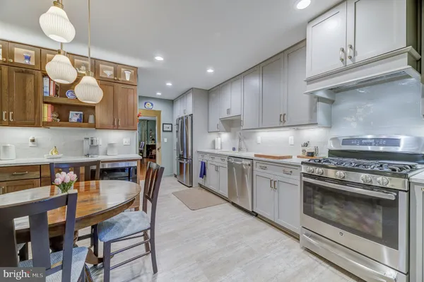 a kitchen with stainless steel appliances granite countertop a stove refrigerator sink and cabinets