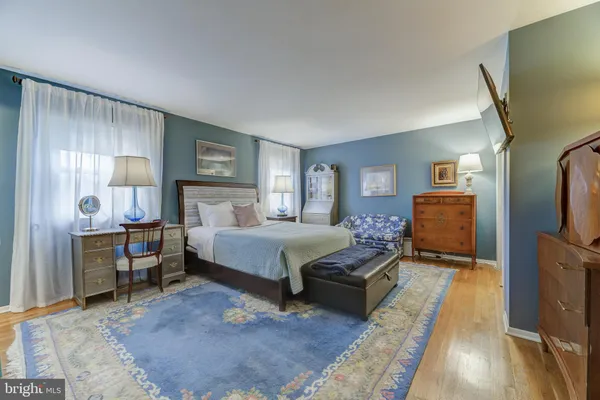 a spacious bedroom with a bed and wooden floor