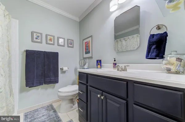 a bathroom with a toilet sink vanity and mirror