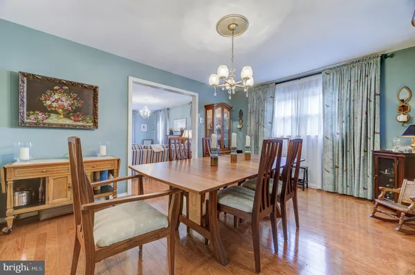 a view of a dining room with furniture a chandelier and wooden floor
