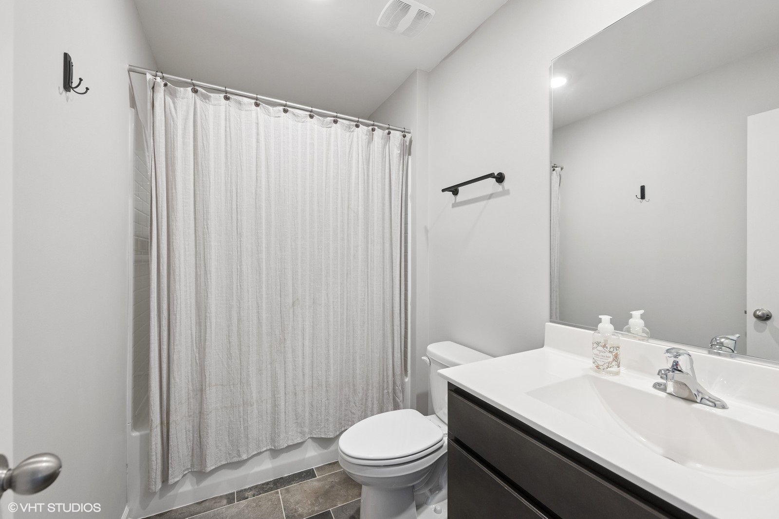 1234 Violet Ct. Joliet, IL 60431 - Photo 17 of 23 a bathroom with a sink a toilet a mirror and shower curtain