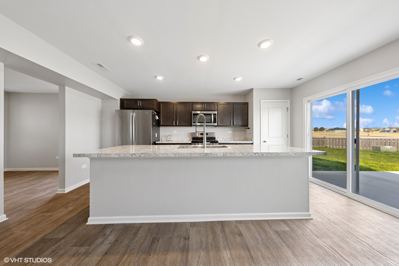 1234 Violet Ct. Joliet, IL 60431 - Photo 9 of 23 a living room with stainless steel appliances granite countertop wooden floor a large window and a kitchen view