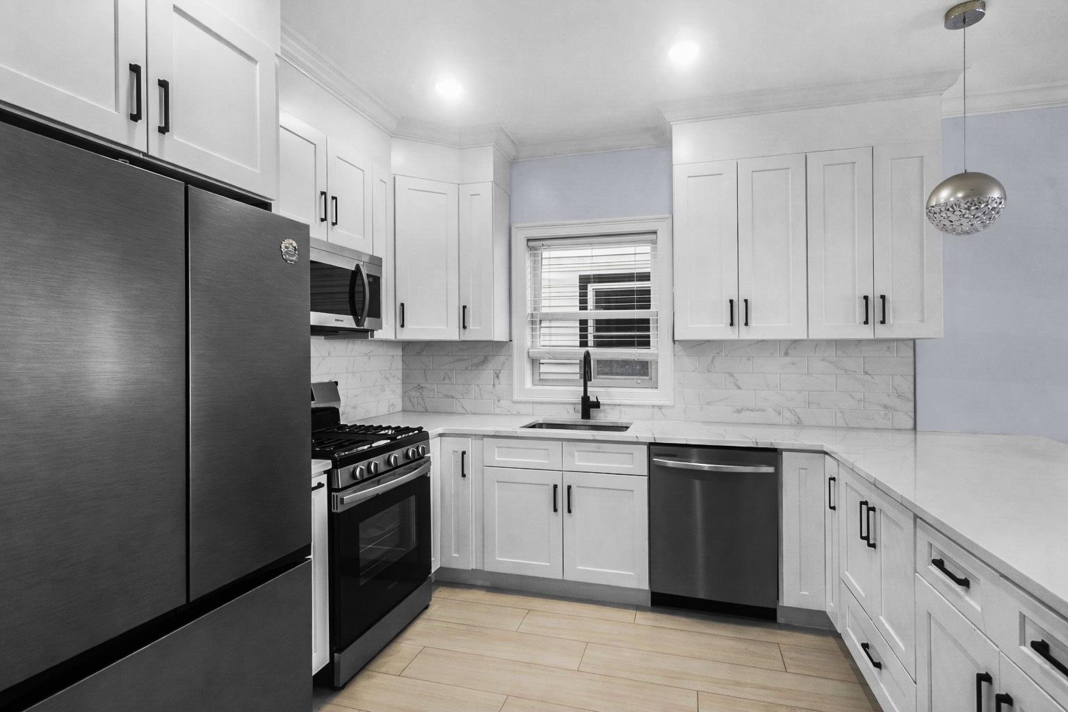 11 South 7th Street Harrison, NJ 07029 - Photo 16 of 29 a kitchen with cabinets stainless steel appliances and a sink