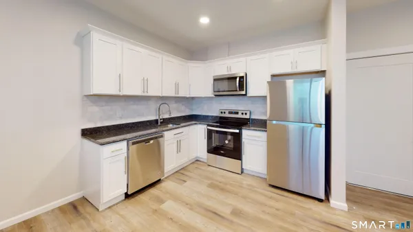 a kitchen with stainless steel appliances granite countertop a refrigerator sink and stove